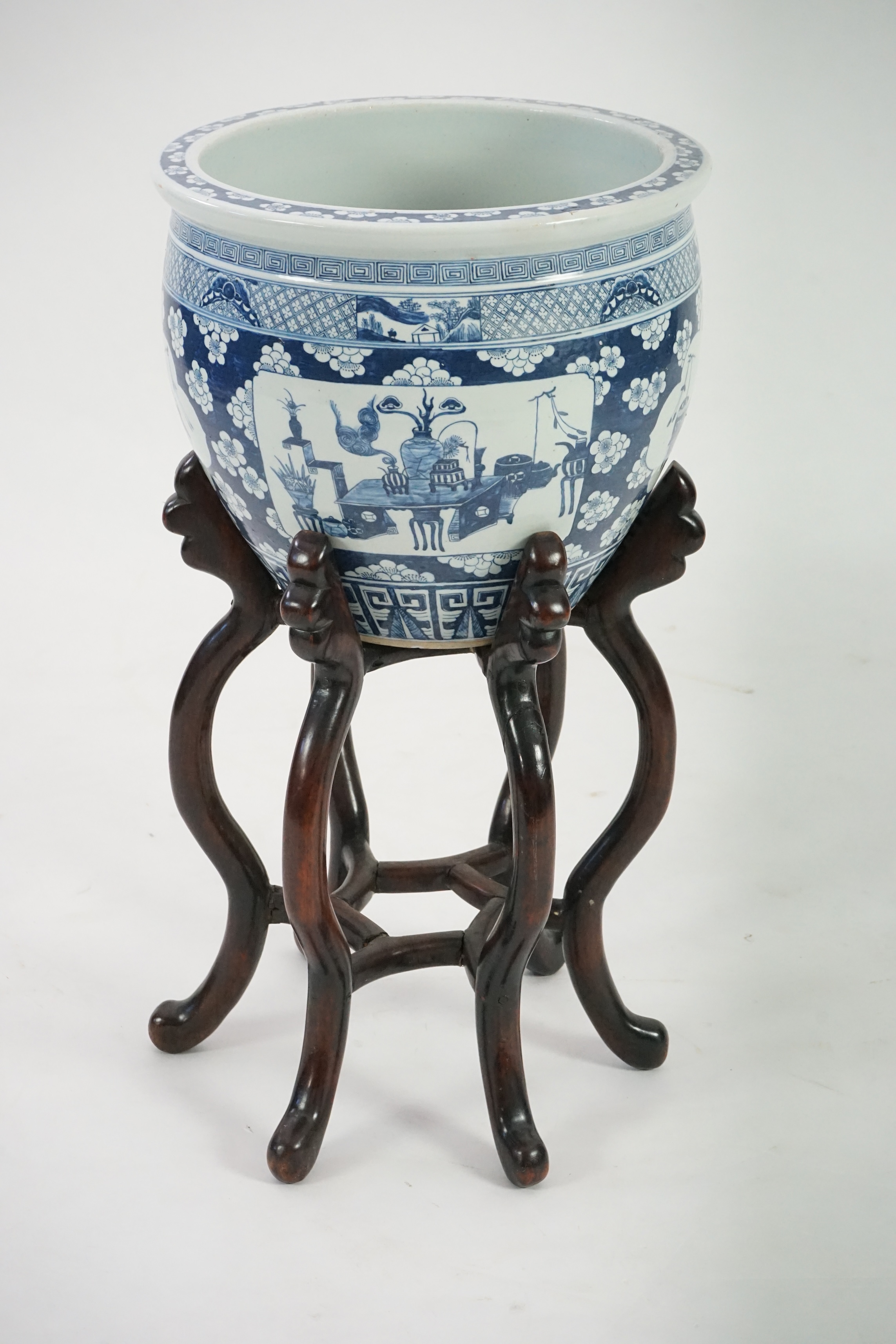 A large Chinese blue and white ‘Hundred Antiques’ jardinere and hongmu stand, late 19th/early 20th century